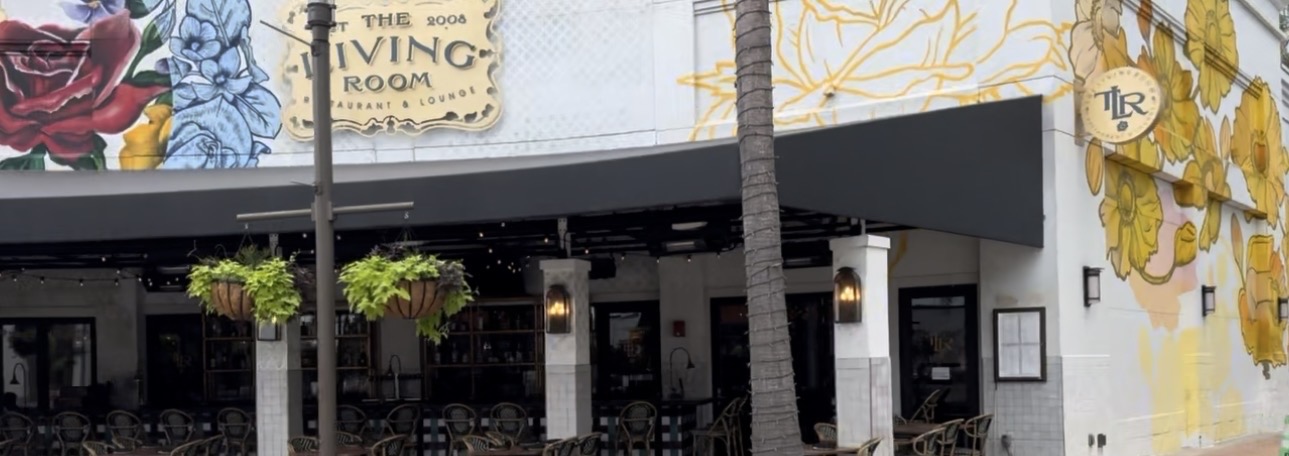 Exterior of The Living Room Restaurant & Lounge at The Shops at Wiregrass in Wesley Chapel, with floral murals and covered patio seating
