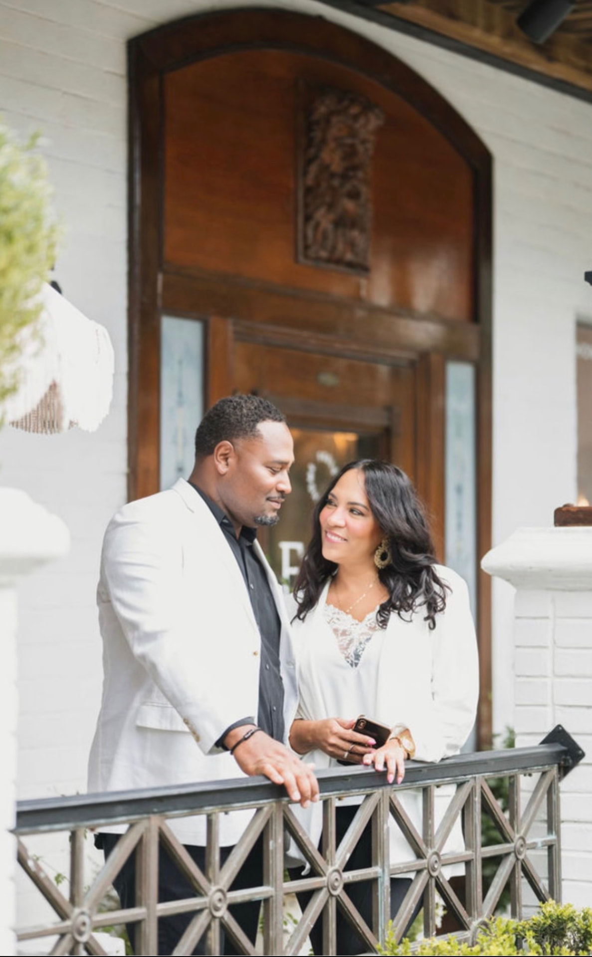 Jevon and Cindy Williams, Wesley Chapel Realtors®, standing together on a porch in Wesley Chapel, Florida.