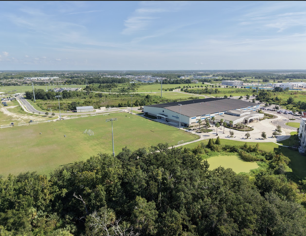 Aerial view of the AdventHealth Center Ice campus, athletic fields and surrounding development along the Wiregrass Ranch corridor in Wesley Chapel, Florida